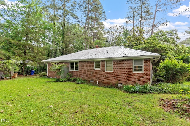7 Woodward Way, Chapel Hill, NC 27516 - view of property exterior featuring a yard, brick siding, and metal roof
