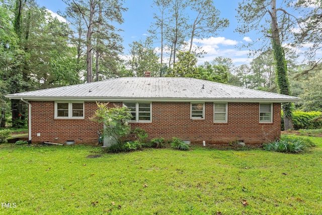 7 Woodward Way, Chapel Hill, NC 27516 - back of property with metal roof, brick siding, a yard, and crawl space