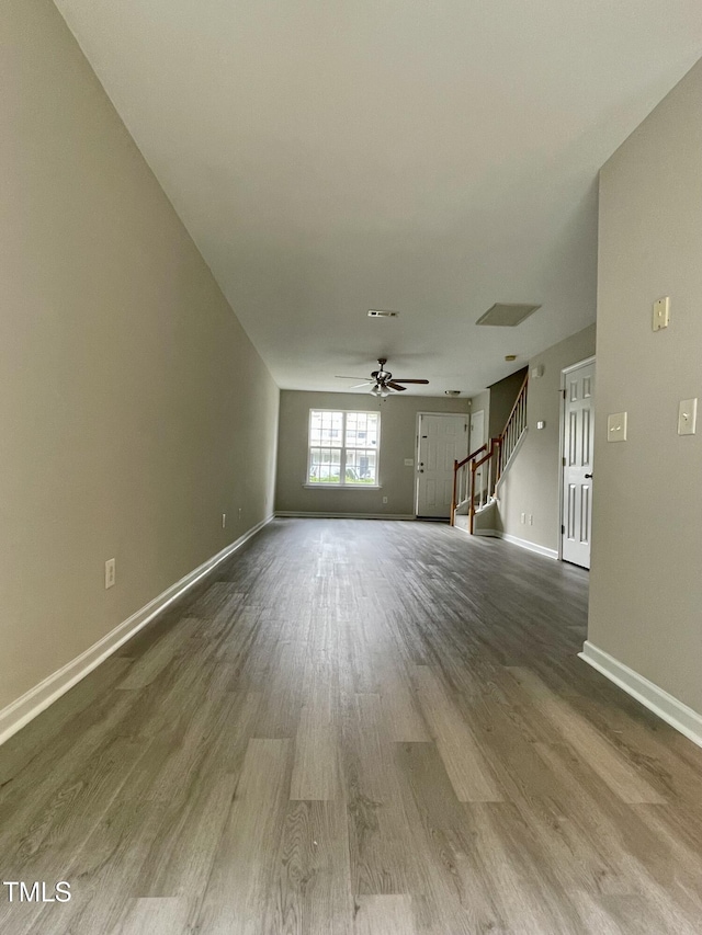 7832 Averette Field Dr, Raleigh, NC 27616 - unfurnished living room with wood finished floors, stairs, ceiling fan, and baseboards