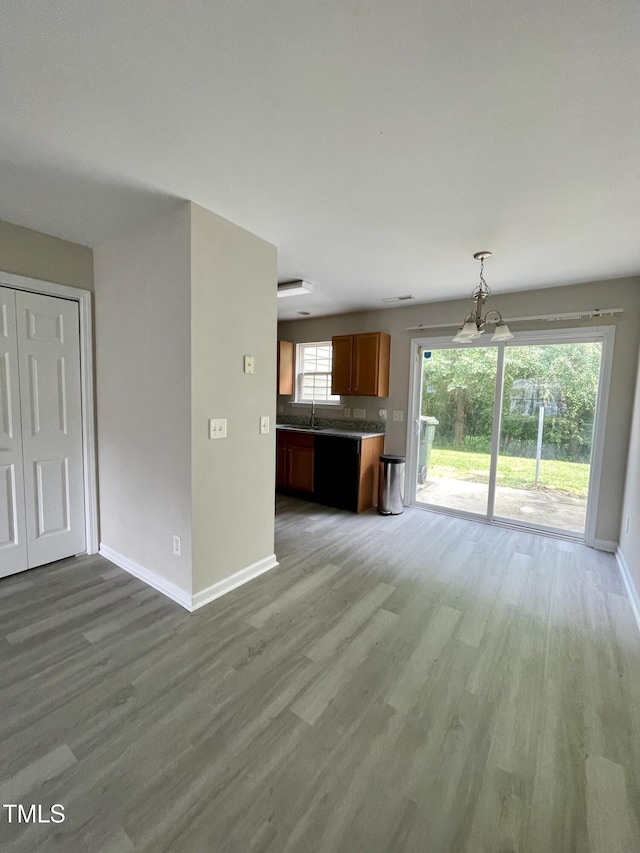 7832 Averette Field Dr, Raleigh, NC 27616 - unfurnished living room featuring light wood-style flooring, baseboards, a sink, and a chandelier