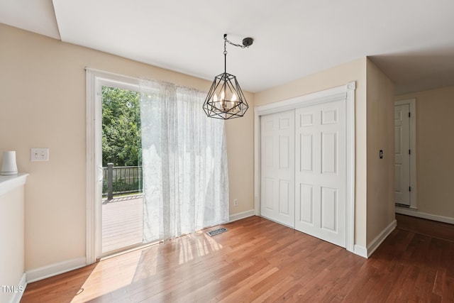 304 Cayman Ave, Holly Springs, NC 27540 - unfurnished dining area with wood finished floors, baseboards, and a chandelier