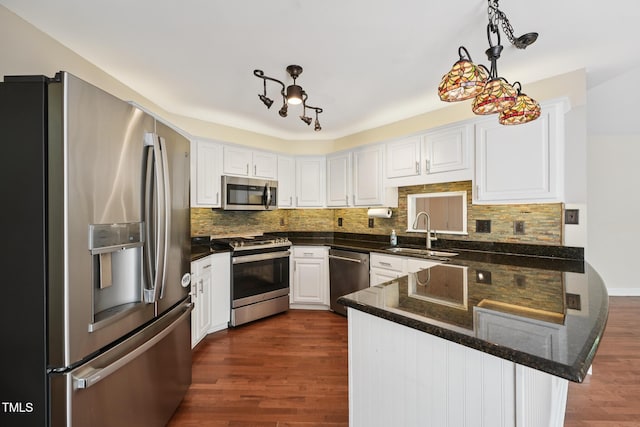304 Cayman Ave, Holly Springs, NC 27540 - kitchen featuring appliances with stainless steel finishes, a sink, a peninsula, dark wood-style flooring, and white cabinets