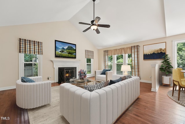 304 Cayman Ave, Holly Springs, NC 27540 - living area with high vaulted ceiling, a lit fireplace, wood finished floors, baseboards, and a ceiling fan