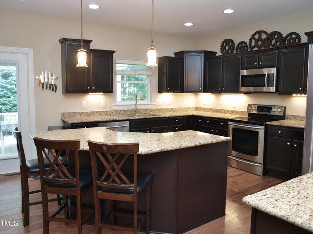 3650 Pleasants Ridge Dr, Wake Forest, NC 27587 - kitchen with appliances with stainless steel finishes, a sink, dark wood-type flooring, a kitchen island, and a breakfast bar
