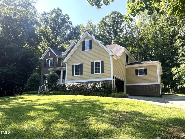 3650 Pleasants Ridge Dr, Wake Forest, NC 27587 - traditional home featuring a front yard, brick siding, and view of wooded area