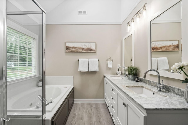 8201 Ivymount Way, Raleigh, NC 27613 - full bathroom with double vanity, wood finished floors, a tub with jets, baseboards, and lofted ceiling