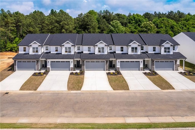 3029 Candlelight Dr, Fayetteville, NC 28311 - multi unit property featuring driveway, stone siding, a wooded view, and a garage