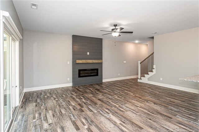 3029 Candlelight Dr, Fayetteville, NC 28311 - unfurnished living room featuring ceiling fan, wood finished floors, stairway, baseboards, and a large fireplace
