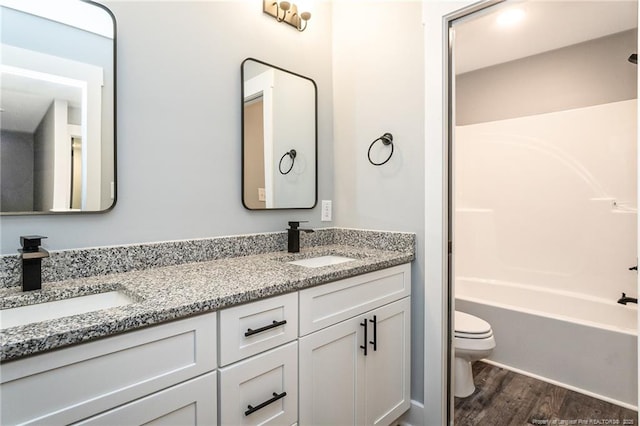 3029 Candlelight Dr, Fayetteville, NC 28311 - bathroom featuring toilet, double vanity, wood finished floors, and shower / bathtub combination