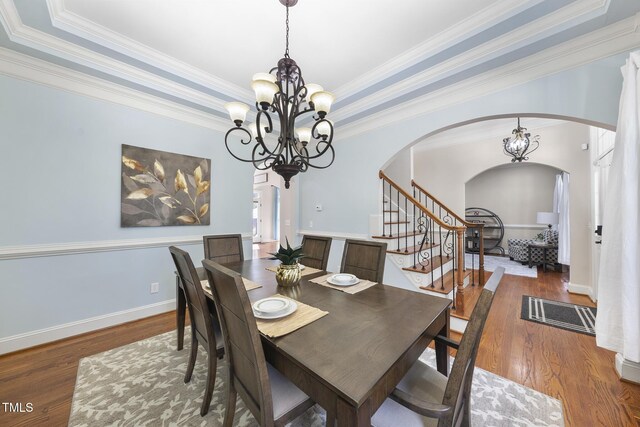 1006 Henny Pl, Raleigh, NC 27614 - dining area with arched walkways, a chandelier, wood finished floors, stairway, and crown molding
