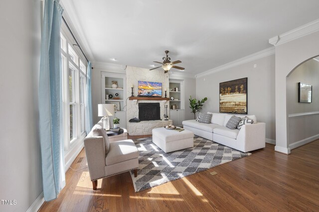 1006 Henny Pl, Raleigh, NC 27614 - living area with baseboards, built in shelves, wood finished floors, arched walkways, and ornamental molding