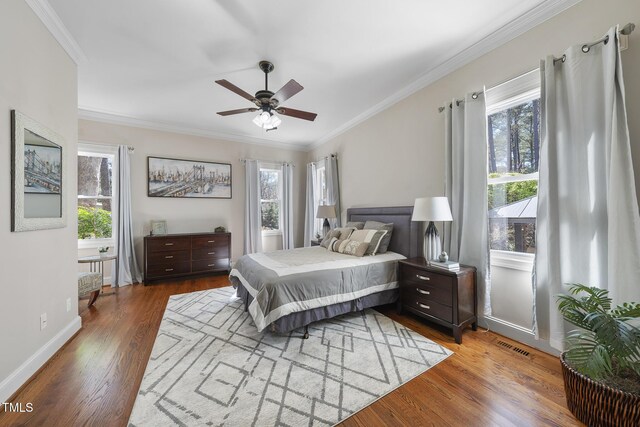 1006 Henny Pl, Raleigh, NC 27614 - bedroom featuring multiple windows, wood finished floors, crown molding, baseboards, and ceiling fan