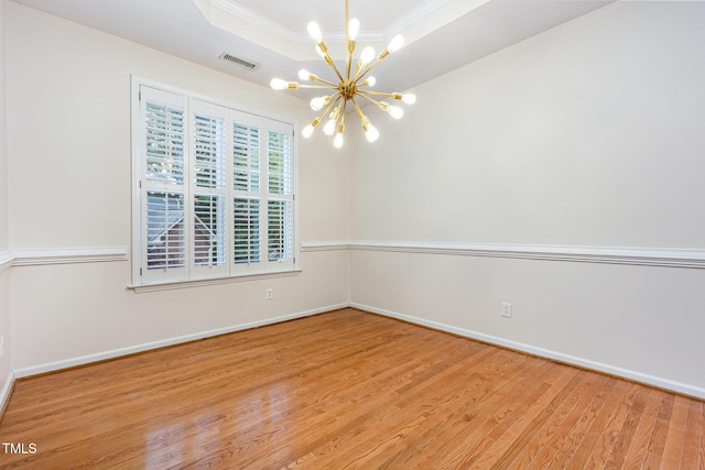 11005 Louson Pl, Raleigh, NC 27614 - empty room featuring a chandelier, crown molding, wood finished floors, a tray ceiling, and baseboards