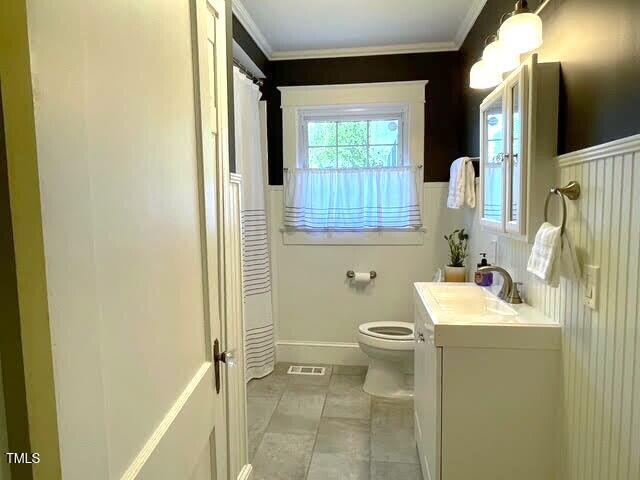 11609 US-401, Fuquay Varina, NC 27526 - bathroom featuring toilet, vanity, ornamental molding, and a wainscoted wall