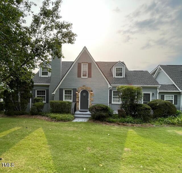 11609 US-401, Fuquay Varina, NC 27526 - view of front of house with a front yard, a chimney, stone siding, and a shingled roof
