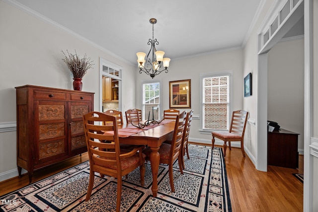 1412 Kings Lassiter Way, Raleigh, NC 27614 - dining room with light wood-type flooring, a chandelier, crown molding, and baseboards