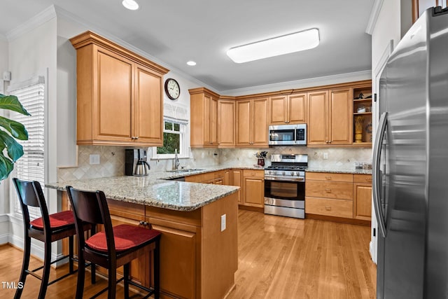 1412 Kings Lassiter Way, Raleigh, NC 27614 - kitchen featuring stainless steel appliances, a peninsula, ornamental molding, a sink, and light wood finished floors