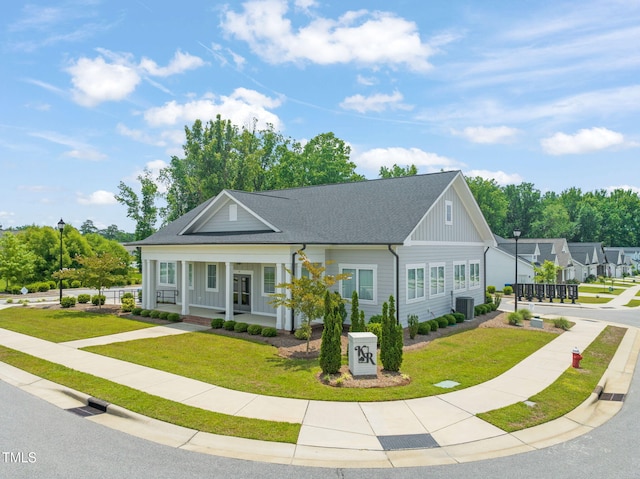 797 S Wilma St, Angier, NC 27501 - view of front of home with central air condition unit, a front lawn, roof with shingles, and a porch