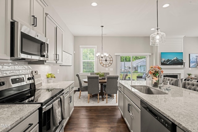 797 S Wilma St, Angier, NC 27501 - kitchen with stainless steel appliances, a sink, recessed lighting, a chandelier, and light stone countertops