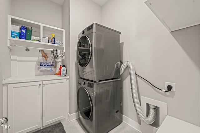 797 S Wilma St, Angier, NC 27501 - laundry area featuring cabinet space, stacked washer / dryer, baseboards, and light tile patterned flooring