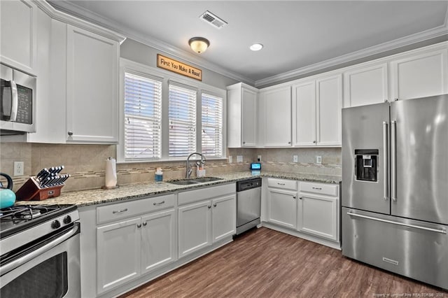 3024 Eagle Crest Ln, Fayetteville, NC 28306 - kitchen featuring appliances with stainless steel finishes, a sink, crown molding, white cabinetry, and decorative backsplash