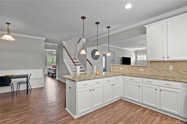 3024 Eagle Crest Ln, Fayetteville, NC 28306 - kitchen with wood finished floors, white cabinets, hanging light fixtures, a peninsula, and ornamental molding