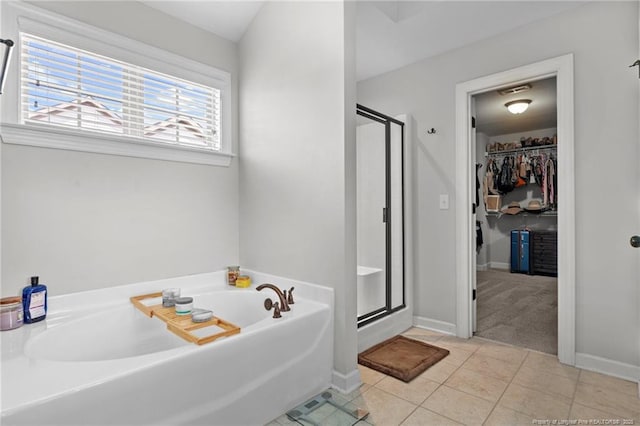 3024 Eagle Crest Ln, Fayetteville, NC 28306 - bathroom featuring a shower stall, a bath, a walk in closet, tile patterned floors, and baseboards