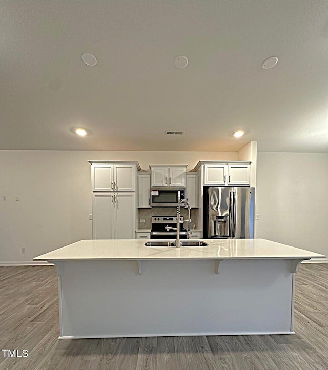 391 Curling Crk Dr, Clayton, NC 27527 - kitchen featuring stainless steel appliances, a sink, a kitchen breakfast bar, light countertops, and a large island with sink