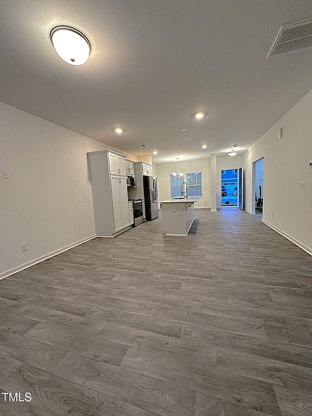 391 Curling Crk Dr, Clayton, NC 27527 - unfurnished living room featuring dark wood finished floors, a sink, a chandelier, recessed lighting, and baseboards