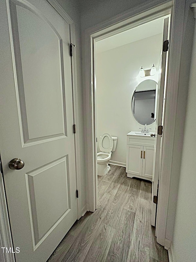 391 Curling Crk Dr, Clayton, NC 27527 - half bath featuring wood finished floors, toilet, vanity, and baseboards