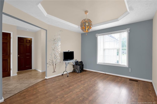 5533 Shady Pine Ct, Hope Mills, NC 28348 - unfurnished living room with a tray ceiling, a chandelier, wood finished floors, and baseboards