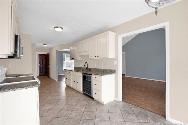 5533 Shady Pine Ct, Hope Mills, NC 28348 - kitchen featuring wine cooler, light tile patterned floors, white cabinets, and baseboards