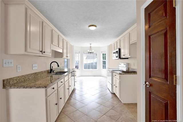 5533 Shady Pine Ct, Hope Mills, NC 28348 - kitchen featuring appliances with stainless steel finishes, a sink, a chandelier, a textured ceiling, and light tile patterned floors