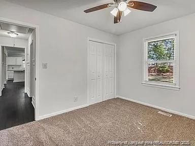 3914 Coventry Rd, Fayetteville, NC 28304 - unfurnished bedroom with attic access, a closet, dark colored carpet, baseboards, and a ceiling fan