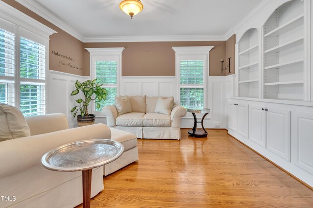 3004 Krogen Ct, Creedmoor, NC 27522 - living room with healthy amount of natural light, a decorative wall, wainscoting, crown molding, and light wood finished floors
