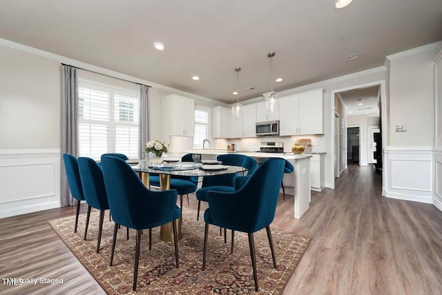 1705 Main Divide Dr, Wake Forest, NC 27587 - dining area featuring crown molding, a wainscoted wall, wood finished floors, a decorative wall, and recessed lighting