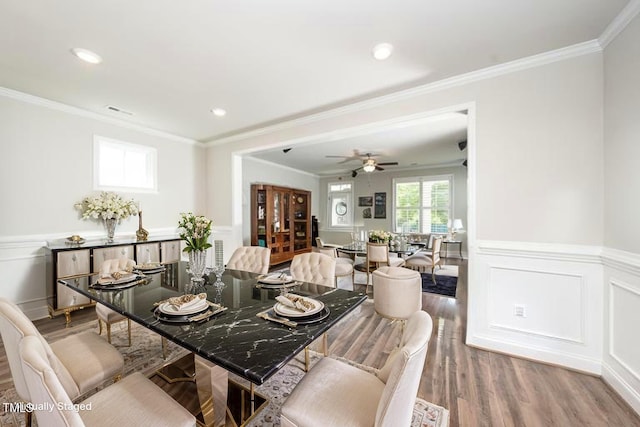 1705 Main Divide Dr, Wake Forest, NC 27587 - dining area with wainscoting, wood finished floors, ornamental molding, a decorative wall, and ceiling fan