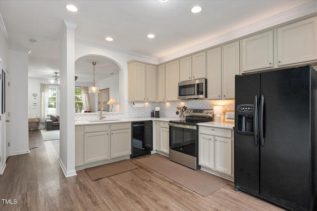 4826 Sir Duncan Way, Raleigh, NC 27612 - kitchen with black appliances, decorative backsplash, light wood finished floors, crown molding, and light countertops