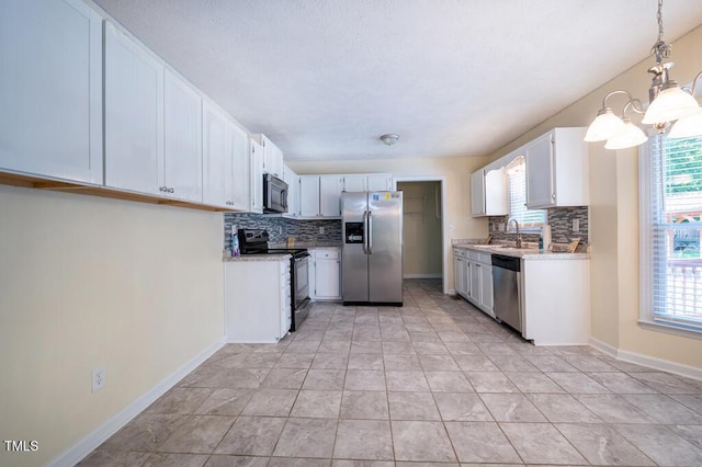 6767 Cedar Chest Ct, Fayetteville, NC 28314 - kitchen with appliances with stainless steel finishes, tasteful backsplash, a chandelier, and healthy amount of natural light