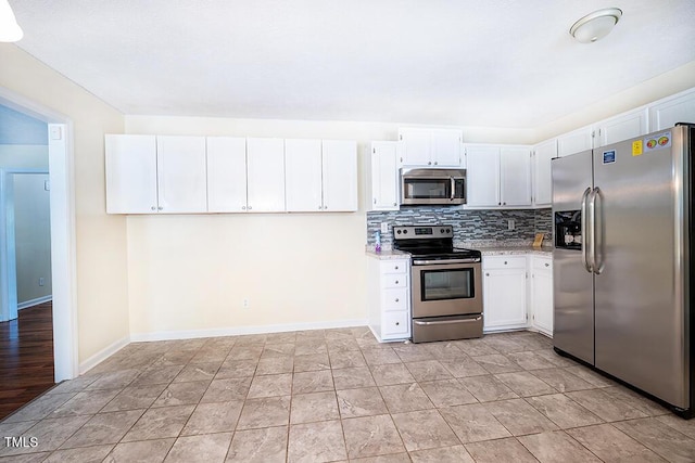 6767 Cedar Chest Ct, Fayetteville, NC 28314 - kitchen featuring appliances with stainless steel finishes, decorative backsplash, white cabinets, baseboards, and light stone countertops