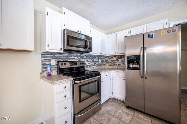 6767 Cedar Chest Ct, Fayetteville, NC 28314 - kitchen featuring stainless steel appliances, light countertops, tasteful backsplash, white cabinets, and light tile patterned floors