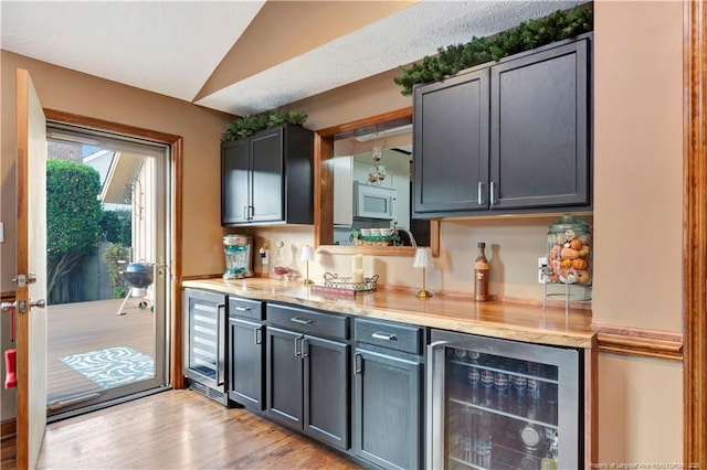 103 Kensington St, Lumberton, NC 28358 - kitchen with wine cooler, lofted ceiling, white microwave, light wood finished floors, and light stone counters