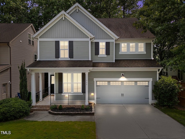 904 Pirouette Ct, Raleigh, NC 27606 - view of front facade with covered porch, board and batten siding, driveway, a garage, and a shingled roof