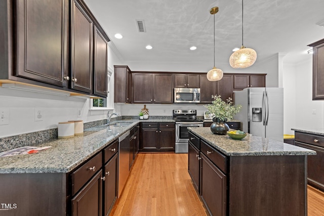 904 Pirouette Ct, Raleigh, NC 27606 - kitchen with appliances with stainless steel finishes, crown molding, dark brown cabinets, light wood-style floors, and a center island