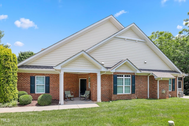 127 Bobwhite Way, Mebane, NC 27302 - view of front facade featuring brick siding, a front yard, a patio area, and roof with shingles