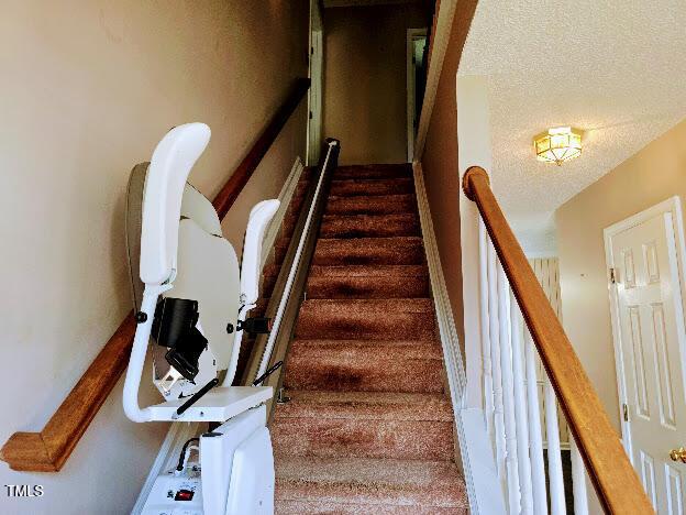 5301 Peacenest Dr, Raleigh, NC 27610 - staircase with a textured ceiling