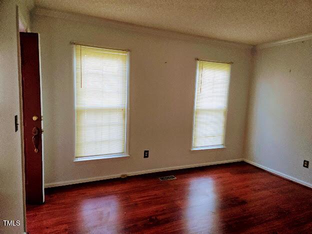 5301 Peacenest Dr, Raleigh, NC 27610 - empty room featuring wood finished floors, baseboards, and a textured ceiling