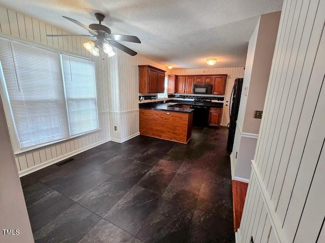 5301 Peacenest Dr, Raleigh, NC 27610 - kitchen with black microwave, a peninsula, brown cabinets, dark countertops, and ceiling fan