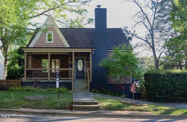 119 W Vernon Ave, Wake Forest, NC 27587 - view of front of house with covered porch, a chimney, and a front lawn