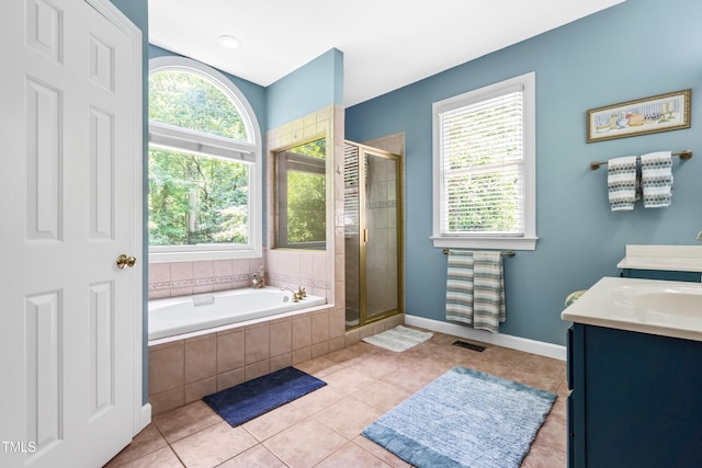 7401 Heartland Dr, Wake Forest, NC 27587 - full bathroom featuring healthy amount of natural light, double vanity, a stall shower, and a garden tub